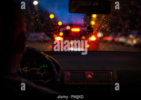 Bokeh lights from traffic jam through a car windscreen on Rainy night in the big city, Stock Photo