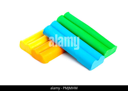 Yellow, orange, green, blue slices of plasticine on a white background. Stock Photo
