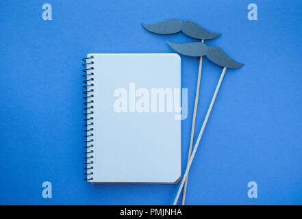 Photo booth props and white notebook on purple background with copyspace. Movember men's health awareness concept. Stock Photo