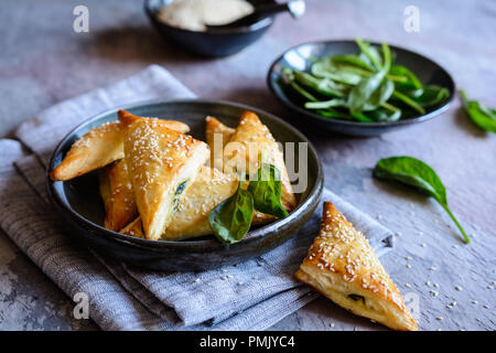 Freshly baked Spanakopita triangles stuffed with spinach and Feta cheese Stock Photo