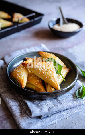 Freshly baked Spanakopita triangles stuffed with spinach and Feta cheese Stock Photo