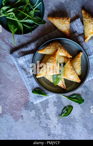 Freshly baked Spanakopita triangles stuffed with spinach and Feta cheese Stock Photo