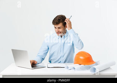 Serious man businessman or engineer sitting in construction site. Courageous middle aged man sit with sad,serious and depressed facial expression. Stock Photo