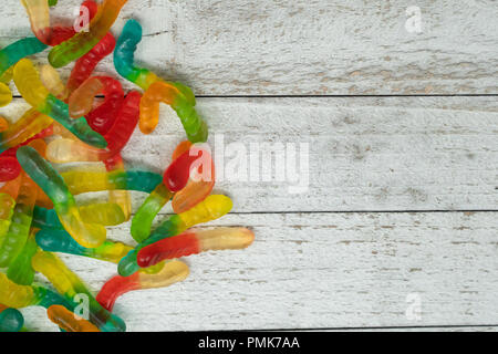 Pile of colorful gummy worms on a wooden background Stock Photo