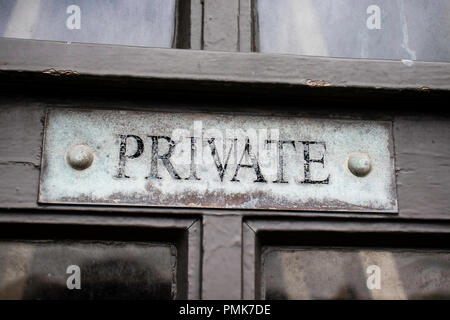 Old, weathered private sign on wooden door Stock Photo