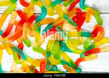 Pile of colorful gummy worms on a wooden background Stock Photo