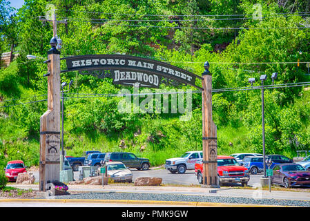 Deadwood, South Dakota, USA, June 6, 2018: The Mainstreet Deadwood sign at the entrance to town and packing lot full of cars. Stock Photo