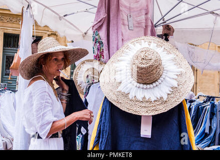 Market stall holder preparing stall, wearing straw hat, holding pen in mouth, Aix-en-Provence, Cote d'Azur, France, Europe Stock Photo