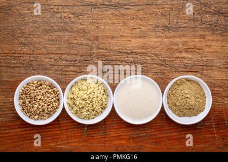 hemp seeds, hearts, milk and protein powder - a set of small ceramic bowlsn a rustic wood with a copy space Stock Photo