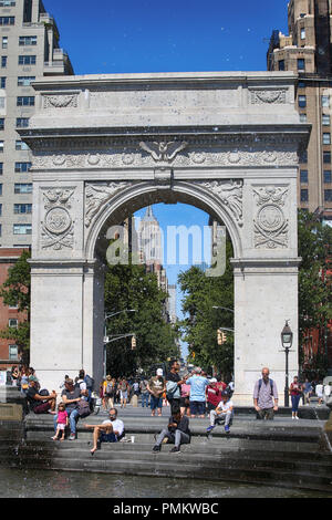 New York, USA – August 23, 2018: People visiting and enjoy the Washington Square Park around the fountain. The park is known for Washington Arch which Stock Photo