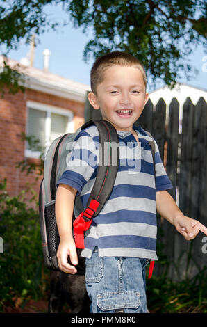 Happy boy with back pack going to school Stock Photo