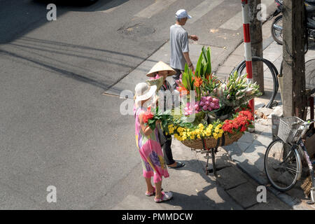 The street vendor sells flowers on the bicycle in the morning in Hanoi Old Quarter, Vietnam. Stock Photo