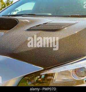 Carbon fiber hood and tallight of a silver car Stock Photo