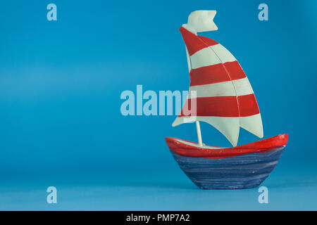 Colourful toy ship isolated on blue background. Decorative holiday theme. Stock Photo