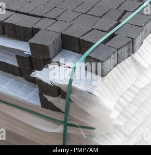 Concrete or cobble gray square pavement slabs or stones for floor, wall or path stacked on wooden pallet in factory warehouse. Industry manufacturing  Stock Photo