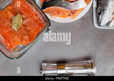 Splitting Fish Fin trout or salmon fish splitting on grey table, salted fillet, filler ...