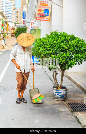 September 14, 2013 - Xiamen, China: Street sweeper sweeps a busy shopping street in center of the city Stock Photo