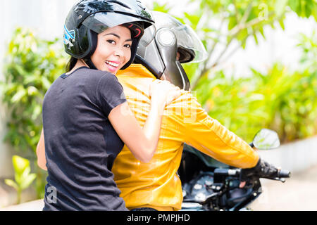 Young woman enjoying riding on motorbike with her boyfriend Stock Photo