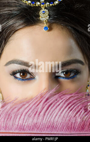 Close up of a woman hiding face with pink feather Stock Photo