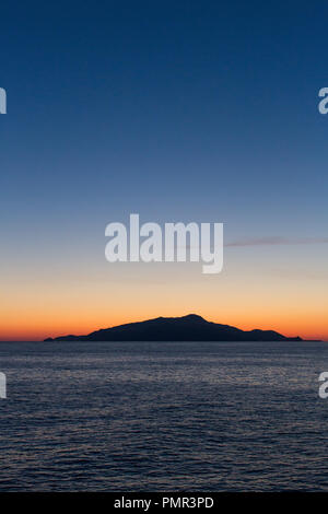 A deserted island, part of the Desertas Islands (Ilhas Desertas) near Madeira, silhouetted in front of a bright orange sunset Stock Photo