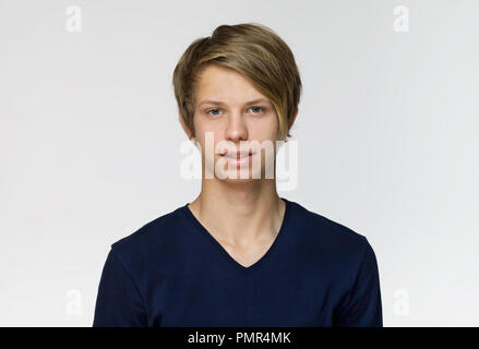 Handsome happy young man wearing blue t-shirt studio portrait against white wall Stock Photo