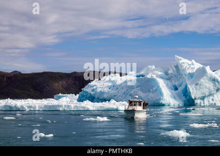 Tourists boat sailing in Tunulliarfik Fjord close to large icebergs from Qooroq icefjord in summer. Narsarsuaq, Kujalleq, Southern Greenland Stock Photo