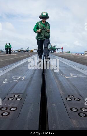 September 19, 2018 - Uss Ronald Reagan (Cvn 76, Philippine Sea - U.S. Navy Aviation Boatswain's Mate (Equipment) 3rd Class Hailey Barela, from Rio Rancho, New Mexico, inspects a catapult track prior to flight operations on the flight deck of the Navy's forward-deployed aircraft carrier USS Ronald Reagan (CVN 76) during Valiant Shield 2018 in the Philippine Sea Sept. 18, 2018. The biennial, U.S. only, field-training exercise focuses on integration of joint training among the U.S. Navy, Air Force and Marine Corps. This is the seventh exercise in the Valiant Shield series that began in 2006. (C Stock Photo