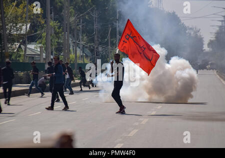 September 19, 2018 - Srinagar, Jammu & Kashmir, India - Kashmiri Shia Muslim youth seen holding a religious flag amid tear smoke during the procession.Police in Indian administered Kashmir imposed a curfew and other restrictions in Srinagar to prevent Shiite Muslims from taking part in Muharram procession. Muharram is a month of mourning in remembrance of the martyrdom of Imam Hussain, the grandson of Prophet Muhammed. Credit: Idrees Abbas/SOPA Images/ZUMA Wire/Alamy Live News Stock Photo