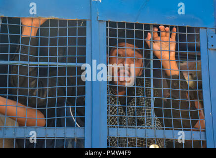 September 19, 2018 - Srinagar, Jammu & Kashmir, India - A Kashmiri youth seen shouting religious slogans inside a police vehicle after being detained for taking part in a religious procession.Police in Indian administered Kashmir imposed a curfew and other restrictions in Srinagar to prevent Shiite Muslims from taking part in Muharram procession. Muharram is a month of mourning in remembrance of the martyrdom of Imam Hussain, the grandson of Prophet Muhammed. Credit: Idrees Abbas/SOPA Images/ZUMA Wire/Alamy Live News Stock Photo