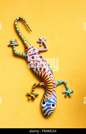 ornamental gekko lizard hanging on wall Stock Photo
