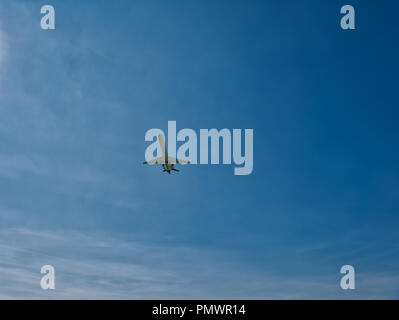 Large aircraft landing approach with blue sky and thin clouds Stock Photo