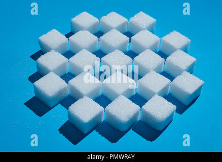 Sugar cubes forming checkered pattern on blue background Stock Photo