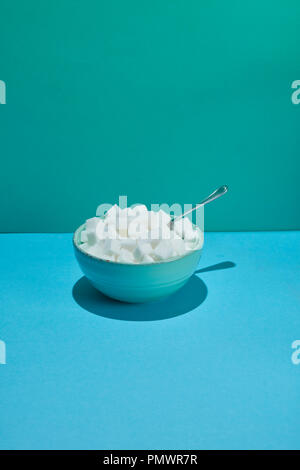 Bowl filled with sugar cubes and spoon Stock Photo