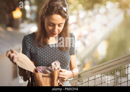 Young woman looking inside her bag Stock Photo