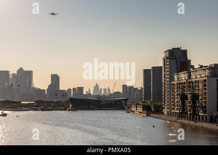 London, England, UK - September 2, 2018: A passenger aircraft approaches City Airport over the Royal Victoria Dock with the skyline of Docklands and t Stock Photo