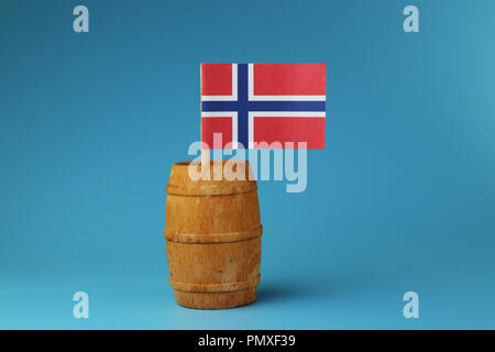 A blue and red national flag of Norway on wooden stick in wooden barrel. Blue background Stock Photo