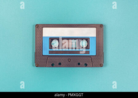 Retro black blue plastic audio cassette tape on green metal background Stock Photo
