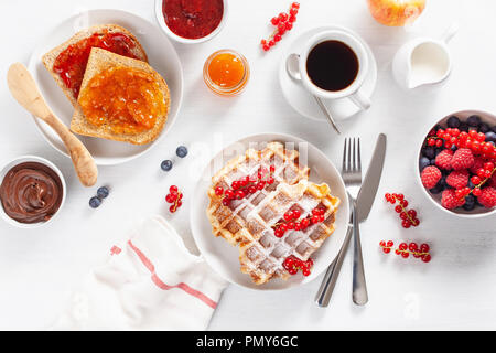 breakfast with waffle, toast, berry, jam, chocolate spread and coffee. Top view Stock Photo