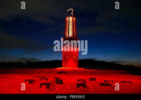 In September 2007, the oversized miner's lamp 'Geleucht' was erected as a landmark by the art professor Otto Piene on the Halde Rheinpreußen in Moers. The snow-covered slope of the heap is shrouded in red light by numerous headlamps. Stock Photo