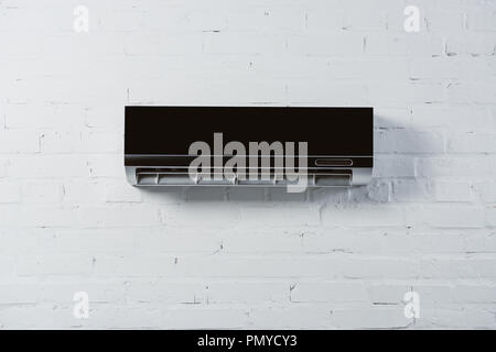 Modern air conditioner hanging on white wall Stock Photo - Alamy