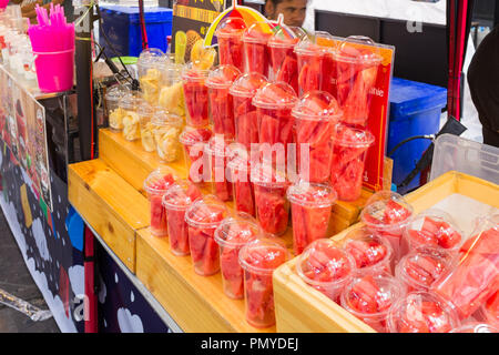 Fresh fruit for sale in plastic containers at a street market in Bangkok, Thailand Stock Photo