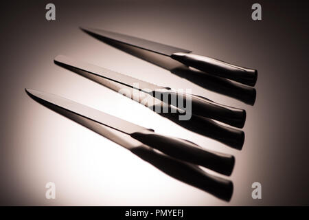 close-up view of various kitchen knives on grey Stock Photo