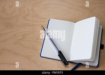 Notebook and black biro pen on a light wood background Stock Photo