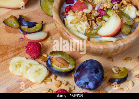 Muesli with berries, fruits and milk - tasty and healthy breakfast. Scattered ingredients and slices of fruits Stock Photo