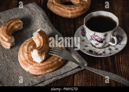 Coffee Break with Eclairs. Stack of Eclairs on the Foreground. Stock Photo