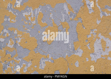 Isolated shot of yellow, grey and white chipping paint, on a stucco wall, in Mexico Stock Photo