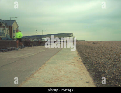 Runner in Hi-viz jacket, keeping fit on Seaford's Esplanade, Sussex, UK. Stock Photo