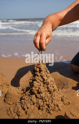 close up man's nand building sand castle at beach Stock Photo