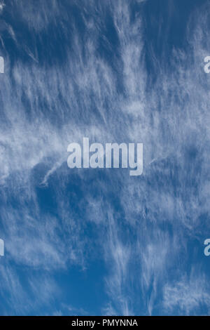 Wispy Cirrus cloud formations against a deep blue sky. Stock Photo
