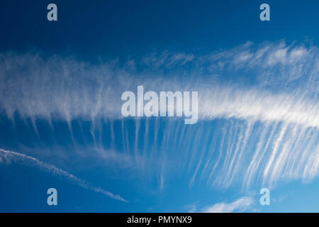 Wispy Cirrus cloud formations against a deep blue sky. Stock Photo